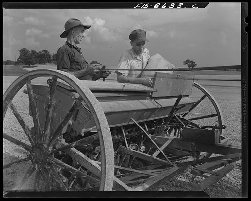 Untitled photo, possibly related to: Beltsville, Maryland. Employees of the United States Department of Agriculture experimental farm demonstrating the care and repair of farm machinery for posters to be used in a "Share and Repair" conservation program