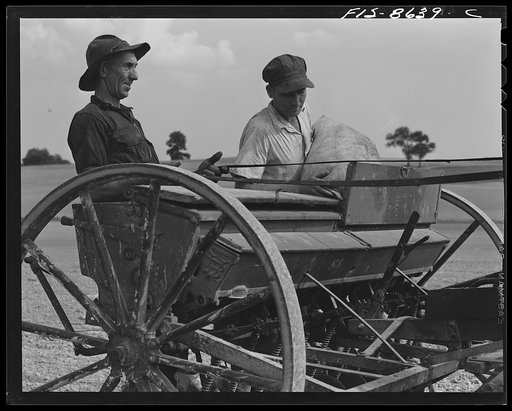 Untitled photo, possibly related to: Beltsville, Maryland. Employees of the United States Department of Agriculture experimental farm demonstrating the care and repair of farm machinery for posters to be used in a "Share and Repair" conservation program