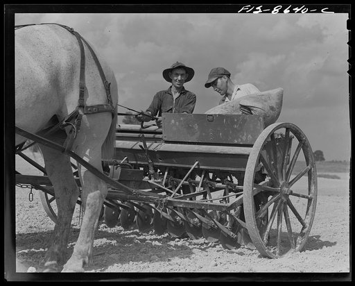 Untitled photo, possibly related to: Beltsville, Maryland. Employees of the United States Department of Agriculture experimental farm demonstrating the care and repair of farm machinery for posters to be used in a "Share and Repair" conservation program