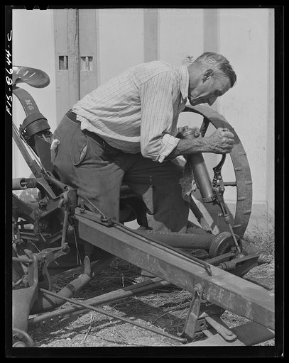 Beltsville, Maryland. Employees of the United States Department of Agriculture experimental farm demonstrating the care and repair of farm machinery for posters to be used in a "Share and Repair" conservation program