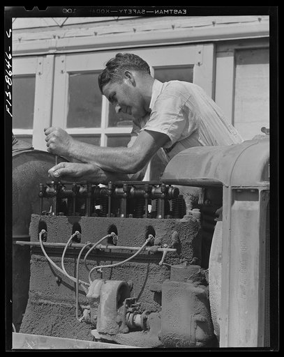 Untitled photo, possibly related to: Beltsville, Maryland. Employees of the United States Department of Agriculture experimental farm demonstrating the care and repair of farm machinery for posters to be used in a "Share and Repair" conservation program