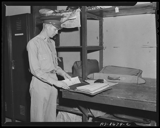 Wayne County Airport, a United States Army Air Corps air ferry command base sixteen miles from Detroit, Michigan. Lieutenant Benton putting his orders into his briefcase. This type of briefcase has almost become an identifying mark of ferry command fliers