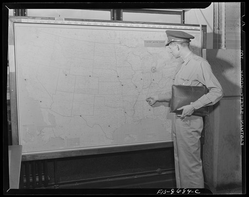 Wayne County Airport, a United States Army Air Corps air ferry command base sixteen miles from Detroit, Michigan. Lieutenant Benton selecting his parachute from the locker room