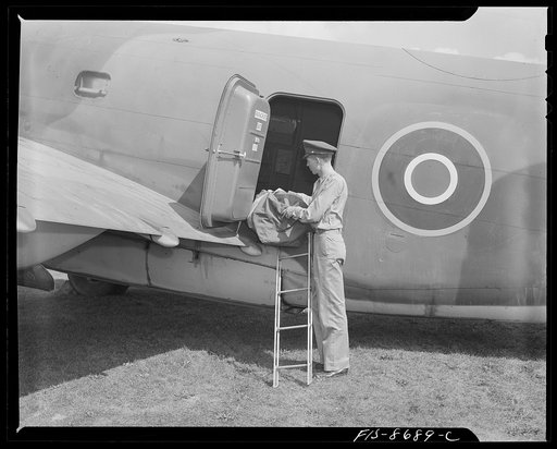 Wayne County Airport, a United States Army Air Corps air ferry command base sixteen miles from Detroit, Michigan. Lieutenant Benton putting his duffle bag aboard the plane