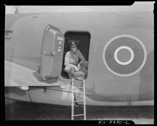Wayne County Airport, a United States Army Air Corps air ferry command base sixteen miles from Detroit, Michigan. Lieutenant Benton putting his duffle bag aboard the plane