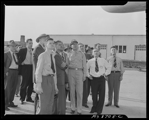 Wayne County Airport, a United States Army Air Corps air ferry command base sixteen miles from Detroit, Michigan. Factory men escorted by Captain Roddy inspecting the ship