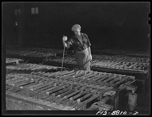 Great Falls, Montana. Electrolytic refinery of Anaconda Copper Mining Company. Inspecting the electrolytic process. By means of this tool which is thrust down and towards the inspector he is able to determine if deposition of copper is proceeding at the normal rate and if there are any short circuit