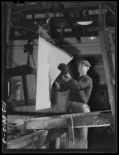 Untitled photo, possibly related to: Great Falls, Montana. Electolytic copper refinery of Anaconda Copper Mining Company. Preparing starting sheets; the workman is shown stripping the starting sheet of electolytic copper; this copper has been deposited on a rolled copper blank, which has been lightl