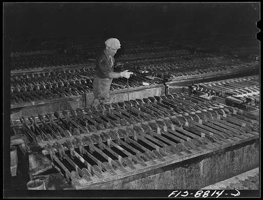 Great Falls, Montana. Electrolytic copper refinery of Anaconda Copper Mining Company. Inspecting the electolytic process. By means of this tool which is thrust down and towards the inspector he is able to detemine if deposition of copper is proceeding at the normal rate and if there are any short ci