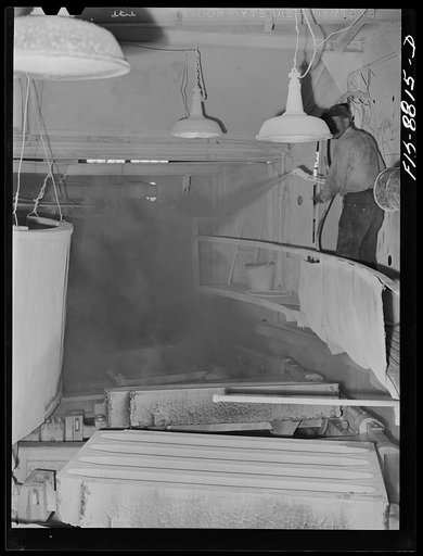 Great Falls, Montana. Furnace refinery of Anaconda Copper Mining Company. Spraying bone ash on the forms in which the refined copper will be poured; this deposit of bone ash prevents the melted copper from burning or sticking to the molds