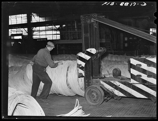 Untitled photo, possibly related to: Great Falls, Montana, Anaconda Wire and Cable Company. Wire rods are stacked in warehouse by this machine which can stack several tons at once