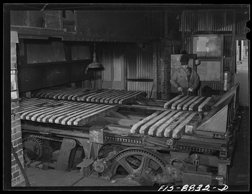 Untitled photo, possibly related to: Great Falls, Montana. Anaconda Wire and Cable Company. Wire bars are placed on a conveyor which pushes them gradually into the heating furnace where they are brought up to correct temperature for rolling into rods