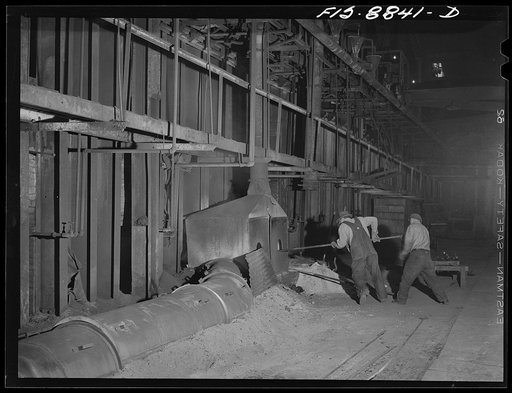 Anaconda smelter, Montana. Anaconda Copper Mining Company. Workmen plug the hold in the refractory material through which the molten stream of copper had been flowing to the ladle from the reverberatory furnace