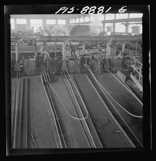 Great Falls, Montana. Anaconda Wire and Cable Company. The finishing mill where copper wire bars are reduced to copper rods by running through a series of rolls. From this mill the rods are coiled and are then treated with a dilute solution of sulphuric acid and washed with water after which they ar
