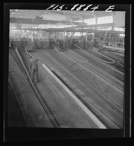 Great Falls, Montana. Anaconda Wire and Cable Company. The finishing mill where copper wire bars are reduced to copper rods by running them through a series of rolls. From this mill the rods are coiled and are then treated with a dilute solution of sulphuric acid and washed with water after which th