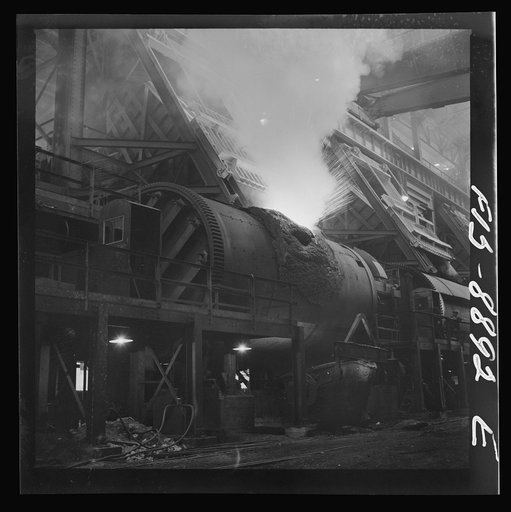 Anaconda smelter, Montana. Anaconda Copper Mining Company. Copper converter in action. Object of converting is to eliminate sulphur and iron; this is accomplished by blowing compressed air through the molten charge. The oxidation products unite with silica which is added to form a slag which floats 