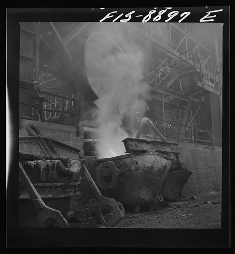 Untitled photo, possibly related to: Anaconda smelter, Montana. Anaconda Copper Mining Company. In the lower left hand corner, copper from the reverberatory furnace is being poured onto a ladle from which it will be carried to the converter; in the upper background, first pourings of slag from the c