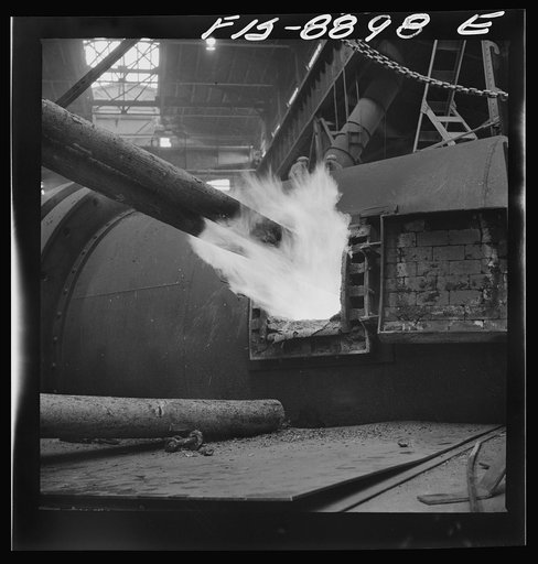Anaconda smelter, Montana. Anaconda Copper Mining Company. Poling in the refining furnace. Wooden poles are plunged into the molten copper; there is a great evolution of gases when this is done and the excess oxygen combines with the carbon of the wood and passes off as carbon monoxide. This refinin