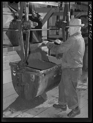 Ben Bow chromite mill, Stillwater County, Montana. Loading a bucket with chrome ore at the mine for transport by aerial tram to Ben Bow mill