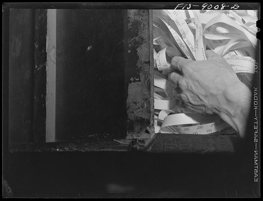New York, New York. Sports department of the New York newspaper. Ticker tape of baseball scores is being emptied and thrown out about 12 AM