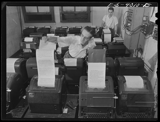 New York, New York. Wire room of the New York newspaper. Copy boy about to tear off dispatch from Associated Press wire