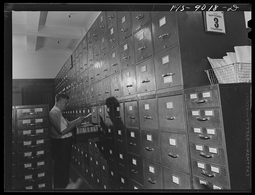 New York, New York. "Morgue" of the New York Times newspaper. Tommy Bracken, head of the Morgue, who has been with the paper fifty-one years and is its oldest employee, looking up something for an editor or writer who has phoned in for information