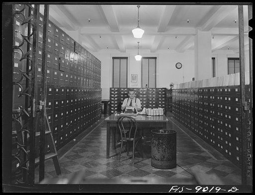 New York, New York. "Morgue" of the New York Times newspaper. Clippings on every conceivable subject are filed here for a reference. Editors and writers phone in for information. In center background is a photograph of Adolph Ochs, founder of the paper