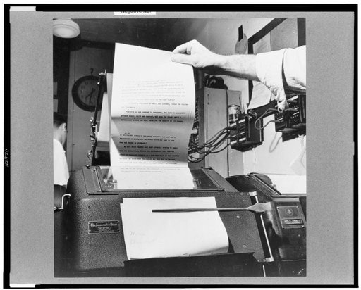 New York, New York. Wire room of the New York Times newspaper. Copy boy about to tear off dispatch coming over Associated Press