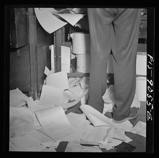 New York, New York. Wire room of the New York Times newspaper. All incoming dispatches are mimeographed, then passed through slot into news room for copy reading and editing. They have to be mimeographed so fast to meet the deadline that many copies fly out of the machine onto the littered floor