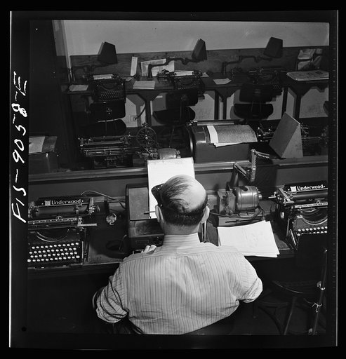 New York, New York. Wire room of the New York Times newspaper. Telegrapher receives dispatch by Western Union from Times correspondent somewhere in the United States