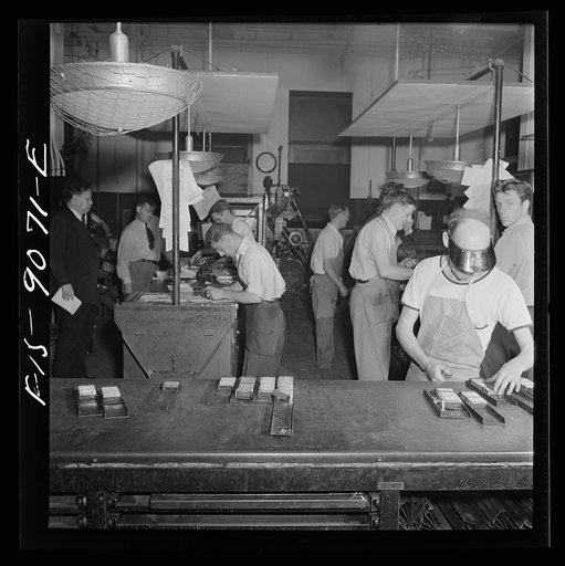 New York, New York. Composing room of the New York Times newspaper. Make-up men pick up linotype slugs from center table