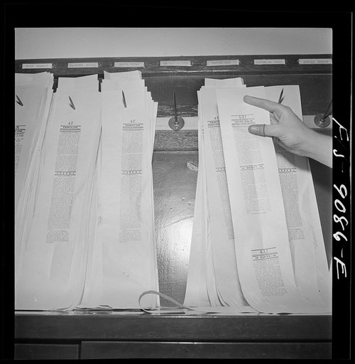 New York, New York. New York Times newspaper syndicate. Proofs of Times news are made available to members. Copy boy hangs them on wall of syndicate room