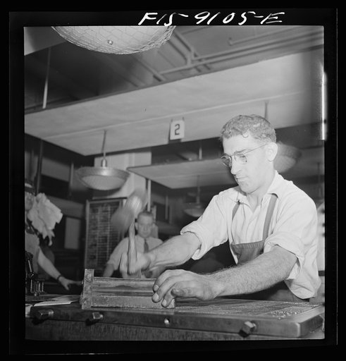New York, New York. Composing room of the New York Times newspaper. Hammering down type on completely made-up page