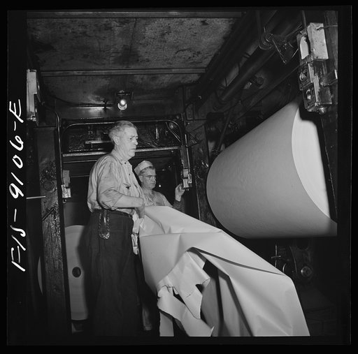 New York, New York. Reel room of the New York Times newspaper. Preparing to thread paper through presses