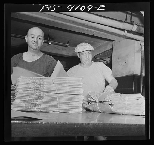New York, New York. Mailroom of the New York Times newspaper. After arriving on a conveyor from the press room, papers are wrapped in bundles according to orders