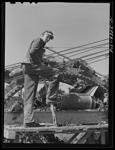Untitled photo, possibly related to: Arkansas-Texas state line to Gurdon, Arkansas. War emergency pipeline from Longview, Texas to Norris City, Illinois. Cleaning the digging machine. This machine digs a five foot deep trench for the pipeline, moving about one mile an hour through soft ground