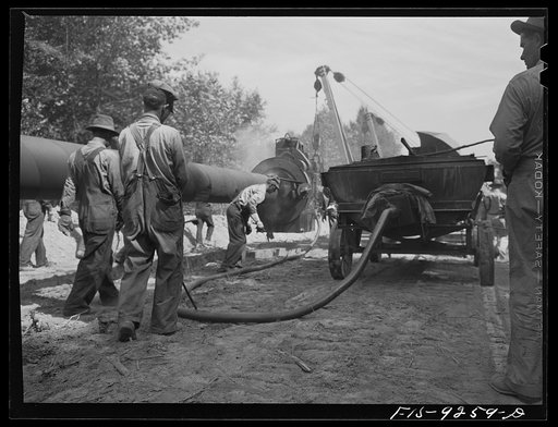 Untitled photo, possibly related to: Little Rock, Arkansas to Missouri-Arkansas state line. War emergency pipeline from Longview, Texas to Norris City, Illinois. Each forty-foot section is welded onto the main line in the stove pipe method of welding line