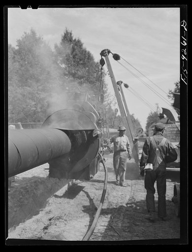 Untitled photo, possibly related to: Little Rock, Arkansas to Missouri-Arkansas state line. War emergency pipeline from Longview, Texas to Norris City, Illinois. The doping drew cleaning, painting, and wrapping the pipe with felt