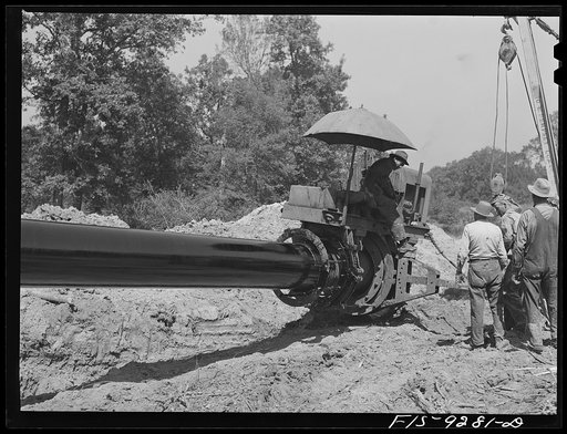 Untitled photo, possibly related to: Arkansas-Texas state line to Gurdon, Arkansas. War emergency pipeline from Longview, Texas to Norris City, Illinois. Priming the pipe with hot asphalt paint