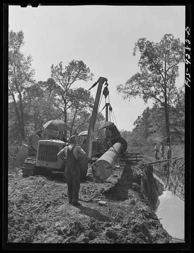 Untitled photo, possibly related to: Little Rock, Arkansas to Missouri-Arkansas state line. War emergency pipeline from Longview, Texas to Norris City, Illinois. Bringing a forty-foot section to main line in stove pipe method of welding