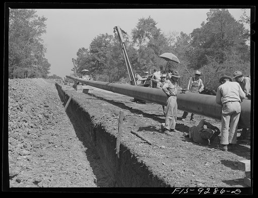 Untitled photo, possibly related to: Little Rock, Arkansas to Missouri-Arkansas state line. War emergency pipeline from Longview, Texas to Norris City, Illinois. Each forty-foot section is welded onto the main line in the stove pipe method of welding line