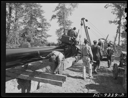 Little Rock, Arkansas. to Missouri-Arkansas state line. War emergency pipeline from Longview, Texas to Norris City, Illinois. Priming pipe with hot asphalt paint. Crew follows machine and touches up by hand space where pipe is welded together