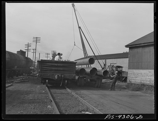Untitled photo, possibly related to: Little Rock, Arkansas to Missouri-Arkansas state line. Bald Knob, Arkansas. War emergency pipeline from Longview, Texas to Norris City, Illinois. Loading forty-foot sections of pipe on stringing trucks
