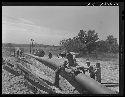 Arkansas-Texas state line to Gurdon, Arkansas. War emergency pipeline from Longview, Texas to Norris City, Illinois. Placing additional felt around piece of pipe which was found defectively wrapped by inspector