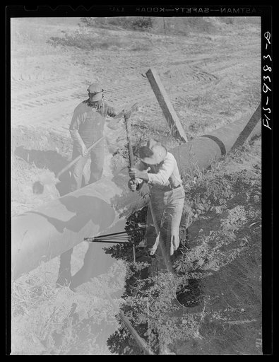 Untitled photo, possibly related to: Longview, Texas to Arkansas state line. War emergency pipeline from Longview, Texas to Norris City, Illinois. Welders on the firing line. Assistant slowly rotates pipe while welders work