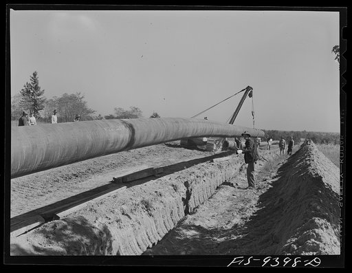 Untitled photo, possibly related to: Longview, Texas to Arkansas state line. War emergency pipeline from Longview, Texas to Norris City, Illinois. Moving 200 foot section of pipe welded to main line by firing line method