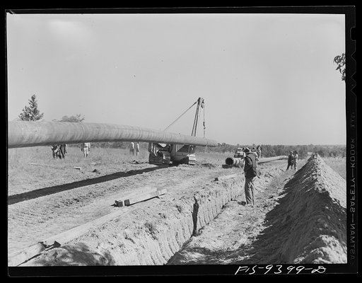 Untitled photo, possibly related to: Longview, Texas to Arkansas state line. War emergency pipeline from Longview, Texas to Norris City, Illinois. Moving 200 foot section of pipe welded to main line by firing line method