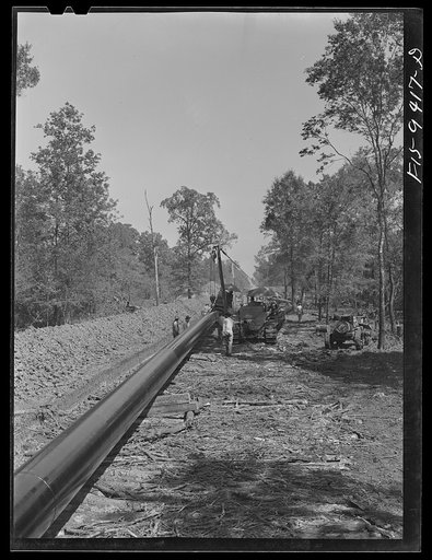 Untitled photo, possibly related to: Little Rock, Arkansas to Missouri-Arkansas state line. War emergency pipeline from Longview, Texas to Norris City, Illinois. Bringing a forty-foot section to main line in stove pipe method of welding