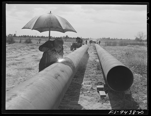 Longview, Texas to Arkansas state line. War emergency pipeline from Longview, Texas to Norris City, Illinois. Welder on the firing line. In the firing line method of welding, four or five sections of pipe are welded together before they are joined to the main line
