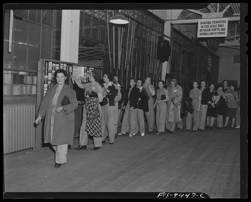 De Soto bomber plant, Detroit, Michigan. Women war workers wearing slacks check out at end of a shift